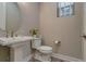 Charming powder room features a pedestal sink, round mirror, and neutral wall color at 5185 Vivian St, Wheat Ridge, CO 80033