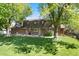 Backyard features a well-maintained lawn with patio furniture and mature trees offering shade and privacy at 10366 E Ida Ave, Greenwood Village, CO 80111