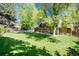 Spacious backyard with lush lawn, mature trees, and patio area offering room for relaxing or entertaining at 10366 E Ida Ave, Greenwood Village, CO 80111