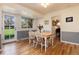 Sunny dining area features light-colored wood flooring, wainscotting, and direct access to the outdoor spaces at 10366 E Ida Ave, Greenwood Village, CO 80111