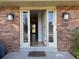 Inviting front entrance featuring a charming brick facade and updated exterior lights at 10366 E Ida Ave, Greenwood Village, CO 80111