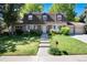 Charming two-story home with manicured lawn, lush landscaping, and a brick facade at 10366 E Ida Ave, Greenwood Village, CO 80111