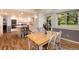 Bright eat-in kitchen features an island with an open shelving base, wooden table, and large window to the backyard at 10366 E Ida Ave, Greenwood Village, CO 80111