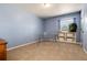 Home office with a glass desk, built-in shelves, and blue accent wall at 10366 E Ida Ave, Greenwood Village, CO 80111