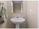 Cozy bathroom with a white pedestal sink, mirror, and light beige paint at 3011 Low Meadow Blvd, Castle Rock, CO 80109