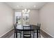 Elegant dining area features a dark wood table set with chairs beneath a modern chandelier and natural light at 3011 Low Meadow Blvd, Castle Rock, CO 80109