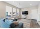 Bright living room with a plush blue sectional couch, natural light, and a TV above a white stand at 3011 Low Meadow Blvd, Castle Rock, CO 80109
