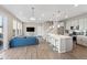 Bright, open-concept living room boasts hardwood floors, modern kitchen with island seating, and a comfortable blue sofa at 3011 Low Meadow Blvd, Castle Rock, CO 80109