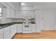 Well-lit kitchen featuring white cabinets, hardwood floors and updated appliances at 2879 S Xanadu Way, Aurora, CO 80014