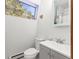 Compact bathroom featuring a toilet, sink, vanity, and mirror with natural light from a window at 456 Copperdale Ln, Golden, CO 80403