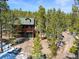Charming multi-story cabin with a green roof and a spacious wooden deck surrounded by lush trees at 456 Copperdale Ln, Golden, CO 80403