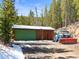 A charming garage with a green door and a blue plow truck in the driveway at 456 Copperdale Ln, Golden, CO 80403