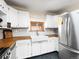 Bright kitchen featuring white cabinets, butcher block countertops, and a farmhouse sink beneath a window at 456 Copperdale Ln, Golden, CO 80403