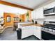 Eat-in kitchen with wood beam and wainscotting, stainless steel appliances, and a view to an adjacent dining area at 456 Copperdale Ln, Golden, CO 80403