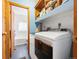 Convenient laundry room with washer, dryer, shelving, and adjacent bathroom at 456 Copperdale Ln, Golden, CO 80403