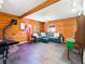 Cozy living room features wood paneling, a comfortable leather sofa, and a rustic wood-burning stove at 456 Copperdale Ln, Golden, CO 80403