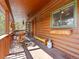 Rustic covered porch with wooden furniture, a cozy seating area, and scenic views of the surrounding landscape at 456 Copperdale Ln, Golden, CO 80403