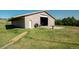 Exterior view of barn featuring a door, a large tire, and a concrete pad at 12518 N Dixon Dr, Parker, CO 80138