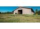 Exterior view of a large barn with an open door on a grassy lot under a bright blue sky at 12518 N Dixon Dr, Parker, CO 80138