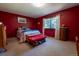 Comfortable bedroom with carpet, bright red walls, and a large window for plenty of natural light at 12518 N Dixon Dr, Parker, CO 80138