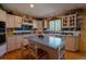 Charming kitchen featuring custom cabinetry, island with seating, and stainless steel appliances at 12518 N Dixon Dr, Parker, CO 80138