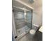 Bathroom featuring glass-enclosed shower, modern gray tiling, and new toilet at 2000 Irving St, Denver, CO 80211