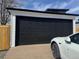 Spacious detached garage with a modern black door and adjacent parking at 2000 Irving St, Denver, CO 80211