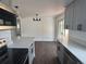 Open-concept kitchen with gray cabinets, quartz countertops, stainless steel appliances, and updated lighting at 2000 Irving St, Denver, CO 80211