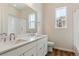 Well-lit bathroom featuring a double sink vanity, sleek fixtures, and a shower with tiled walls at 4978 Hickory Oaks St, Castle Rock, CO 80104