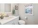Charming bathroom with a vanity, framed mirror, toilet and stained glass window at 3178 Geneva Ct, Denver, CO 80238