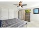 Bedroom features large closet doors, a ceiling fan, and a dresser with a TV at 3178 Geneva Ct, Denver, CO 80238