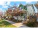 Inviting two-story home with a covered front porch, professional landscaping, and a well-maintained lawn at 3178 Geneva Ct, Denver, CO 80238