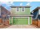 Two-story home featuring a green exterior, an attached garage, and an inviting, well-maintained front yard at 3178 Geneva Ct, Denver, CO 80238