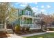 Beautiful two-story home with a covered porch, green exterior paint, and a well-manicured lawn at 3178 Geneva Ct, Denver, CO 80238