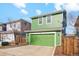 Attached two-car garage with a green door and ample parking space on a sunny day at 3178 Geneva Ct, Denver, CO 80238