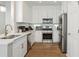 Well-equipped kitchen featuring modern appliances, white cabinetry, and granite countertops with gold hardware at 3178 Geneva Ct, Denver, CO 80238