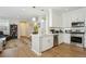 Contemporary white kitchen with stainless steel appliances, stylish backsplash, and convenient island with sink at 3178 Geneva Ct, Denver, CO 80238