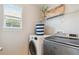 Well-lit laundry room including a washer, dryer, shelving, and a window at 3178 Geneva Ct, Denver, CO 80238