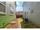 Small side yard area with rock cover, featuring an air conditioning unit and a separation between houses at 3178 Geneva Ct, Denver, CO 80238
