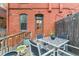 Inviting back deck with outdoor seating, table, flower pots, string lights, and brick exterior at 39 S Grant St, Denver, CO 80209