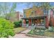 Charming red brick home features a cozy front porch, garden beds, and a well-maintained lawn at 39 S Grant St, Denver, CO 80209