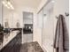 Bright bathroom with a glass-enclosed shower, dark granite vanity and easy access to the bedroom at 17448 E 103Rd Pl, Commerce City, CO 80022
