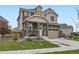 Inviting two-story home with manicured lawn, stone columns, and attached two-car garage at 17448 E 103Rd Pl, Commerce City, CO 80022