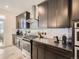 Well-equipped kitchen with dark cabinets, stainless steel appliances, and modern backsplash at 17448 E 103Rd Pl, Commerce City, CO 80022
