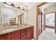 Bathroom featuring a double sink vanity with granite countertops, stylish lighting, and access to bedroom at 514 Creekside Ct, Golden, CO 80403