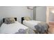 Bright bedroom features two twin beds with designer bedding, wood floors, and modern lighting at 1700 Bassett St # 504, Denver, CO 80202