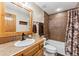 Neutral bathroom with wooden mirror and cabinetry, brown tiled walls, and shower-tub combination at 200 Rachel Ln, Breckenridge, CO 80424