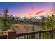 Expansive mountain view from the deck, enhanced by a colorful sunset and lush evergreens in the foreground at 200 Rachel Ln, Breckenridge, CO 80424