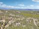 Stunning aerial view of a serene, wooded community with lush trees and rolling hills at 10469 Christopher Dr, Conifer, CO 80433
