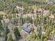 The aerial view reveals the property nestled among lush trees in a serene, private setting at 10469 Christopher Dr, Conifer, CO 80433
